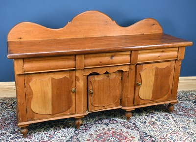 Lot 2957 - A pine sideboard with three drawers above...