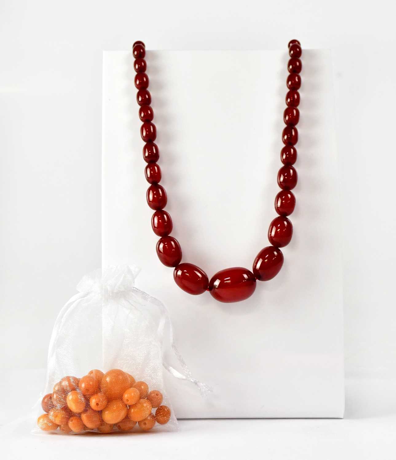 Lot 1090 - A cherry amber style graduated bead necklace,...
