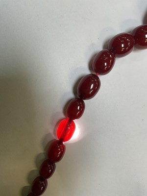 Lot 1090 - A cherry amber style graduated bead necklace,...