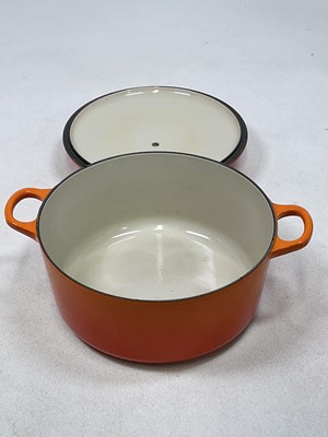 Lot 197 - LE CREUSET; a Volcanic Orange cast iron round...