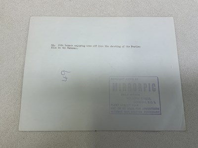 Lot 397 - JOHN LENNON; a black and white photograph...