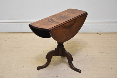 Lot 1066 - An oak drop-leaf table on turned column and...