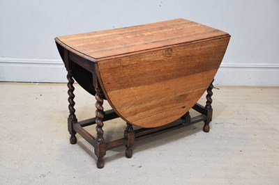 Lot 1060 - An early 20th century oak oval drop-leaf...