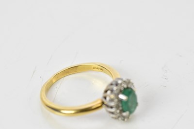 Lot 100 - An 18ct yellow gold diamond and emerald oval...