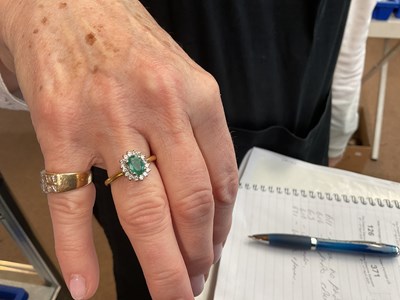 Lot 100 - An 18ct yellow gold diamond and emerald oval...