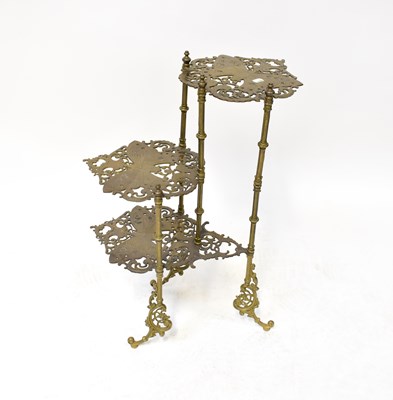 Lot 85 - A decorative three-tier brass table with...