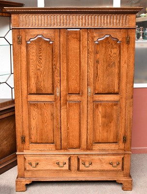 Lot 3030 - A reproduction oak wardrobe with moulded...
