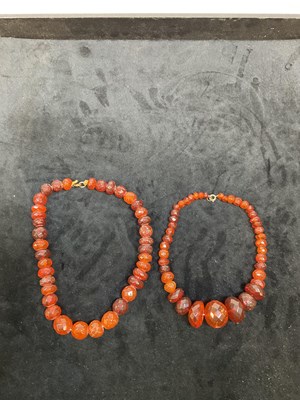 Lot 334 - Two graduated Baltic amber bead necklaces,...