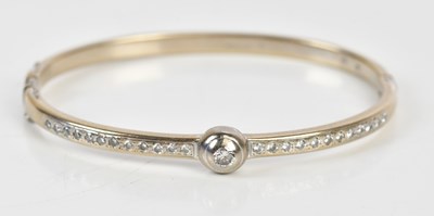 Lot 209 - An 18ct white gold diamond set hinged bangle,...