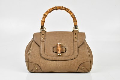 Lot 642 - GUCCI; a tan pebbled leather handbag with top...