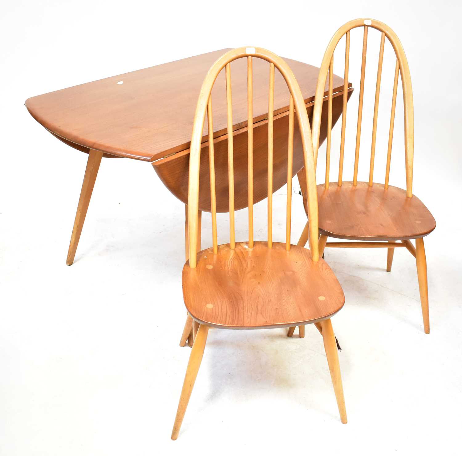 Lot 11 - ERCOL; an elm oval drop-leaf table, raised on...