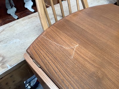 Lot 11 - ERCOL; an elm oval drop-leaf table, raised on...