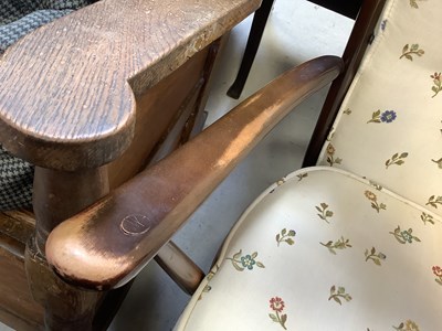 Lot 9 - ERCOL; a dark stained elm open arm chair with...