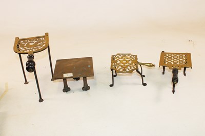 Lot 1126 - Four Georgian brass trivets, two with turned...
