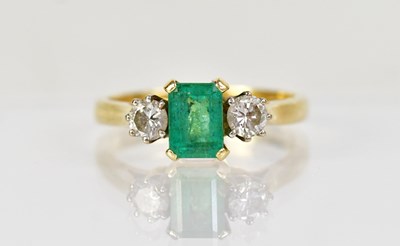 Lot 1276 - An 18ct yellow gold ring set with an emerald,...