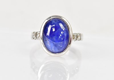 Lot 1275 - An 18ct white gold ring set with an oval blue...
