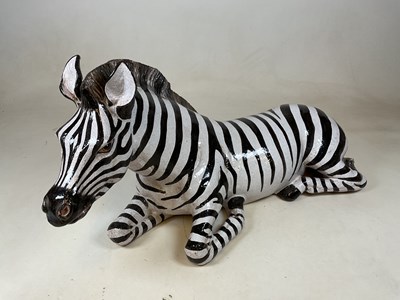 Lot 287 - A large pottery figure of a recumbent zebra,...