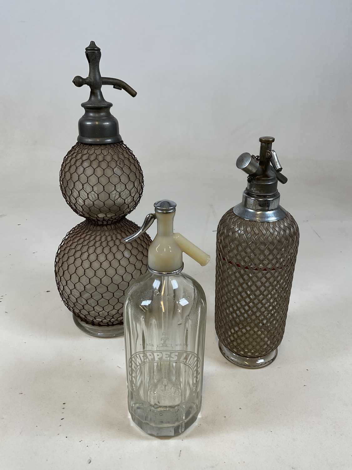 Lot 41 - A double gourd soda syphon with mesh cage and...