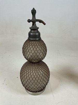 Lot 41 - A double gourd soda syphon with mesh cage and...