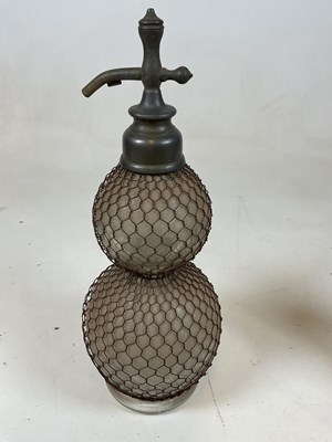 Lot 41 - A double gourd soda syphon with mesh cage and...