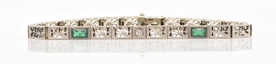 Lot 23 - A white metal diamond and emerald set tennis...