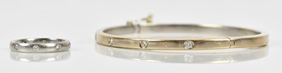 Lot 16 - An 18ct white gold diamond set snap bangle,...