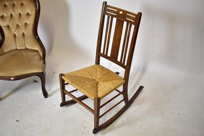 Lot 1649 - An Arts and Crafts inlaid oak rush seated rocking chair