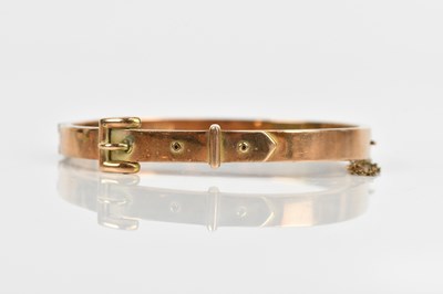Lot 49 - A yellow metal hinged snap bangle with buckle...
