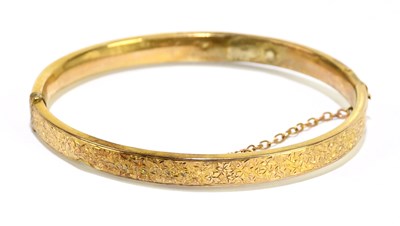 Lot 1267 - A 9ct yellow gold snap bangle, with chased...