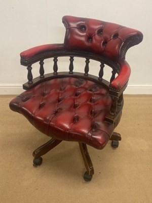 Lot 756 - A red leather button back captain's chair on...