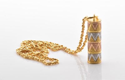Lot 516 - A yellow metal three tone cylinder pendant on...