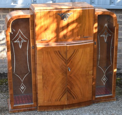 Lot 68 - An Art Deco walnut cocktail cabinet flanked by...