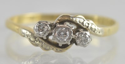 Lot 1219 - An 18ct gold three stone diamond set crossover...