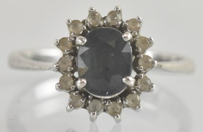Lot 1262 - A white metal ring, with four claw set cushion...