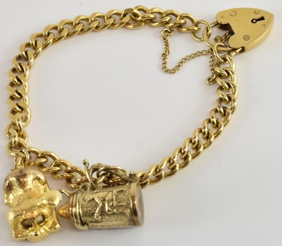 Lot 1336 - A 9ct gold flat curb charm bracelet, with two...