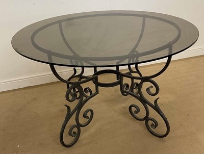 Lot 800 - An ornate metal worked table with smoked glass...