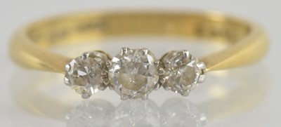 Lot 1231 - An 18ct gold three stone diamond ring, the...