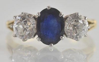 Lot 1208 - A diamond and sapphire set ring, the claw set...