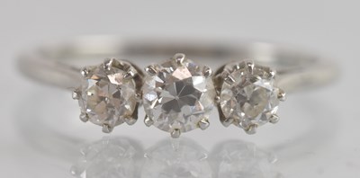 Lot 1216 - A platinum three stone diamond set ring, the...