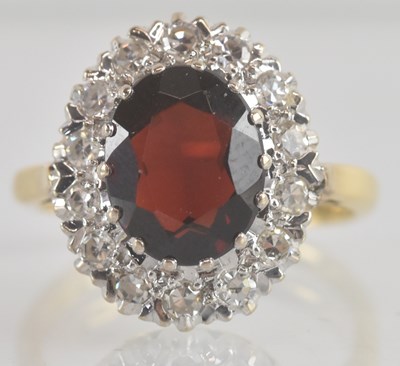 Lot 1225 - A gold garnet and diamond ring, the central...