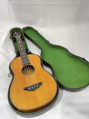 Lot 184 - A cased four string ukulele with mother of...