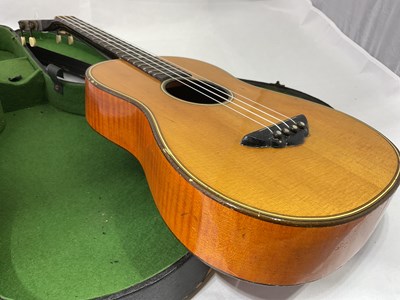 Lot 184 - A cased four string ukulele with mother of...