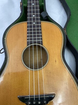 Lot 184 - A cased four string ukulele with mother of...