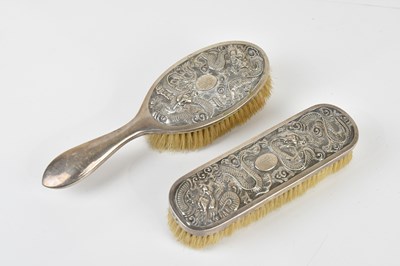 Lot 2167 - Two Chinese white metal hair brushes decorated...