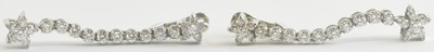 Lot 1302 - A pair of white metal diamond set floral drop...
