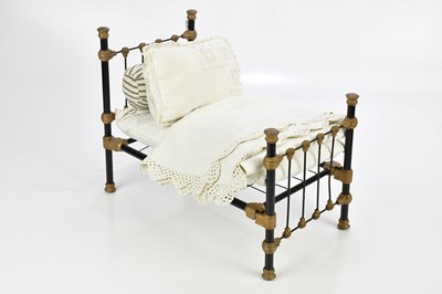Lot 2103 - A patinated metal doll's bed modelled as a...