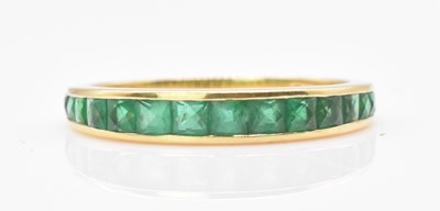 Lot 470 - An 18ct yellow gold emerald half eternity ring,...
