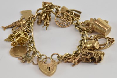 Lot 1335 - A 9ct yellow gold charm bracelet, with...