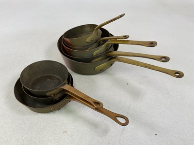 Lot 220 - Two graduated sets of copper pans, largest...