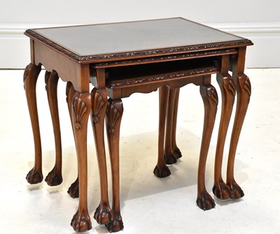 Lot 1129 - A walnut nest of three graduated coffee tables...